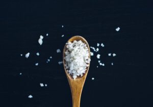 cuillère en bois contenant des cristaux de sel marin recette cheveux