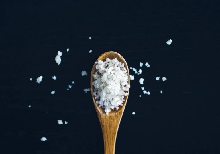 cuillère en bois contenant des cristaux de sel marin recette cheveux